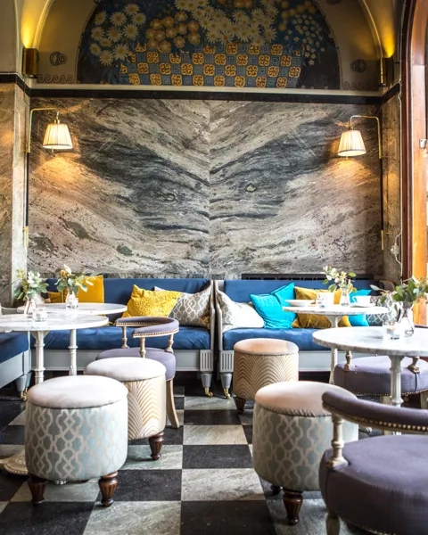 En restaurang med rutigt golv och en stor målning på väggen.