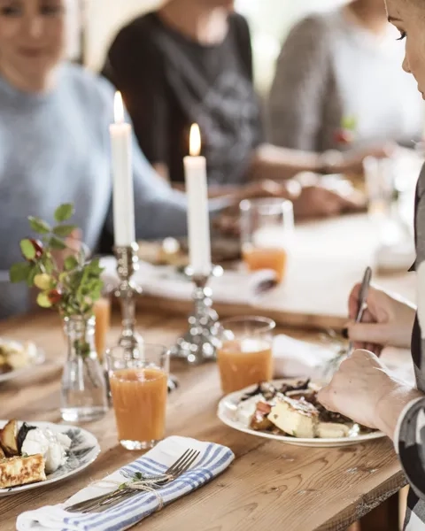 En grupp människor som sitter runt ett bord och äter mat.