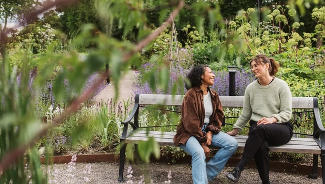 Några kvinnor sitter på en träbänk.