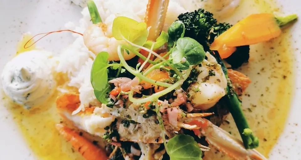 En tallrik med mat på ett träbord.