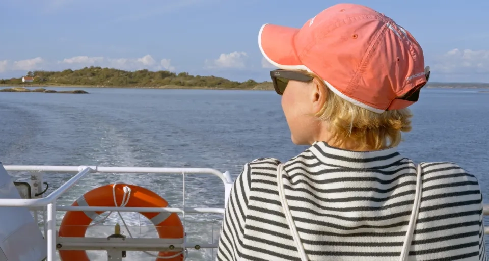 A woman on a boat looking out at the water.