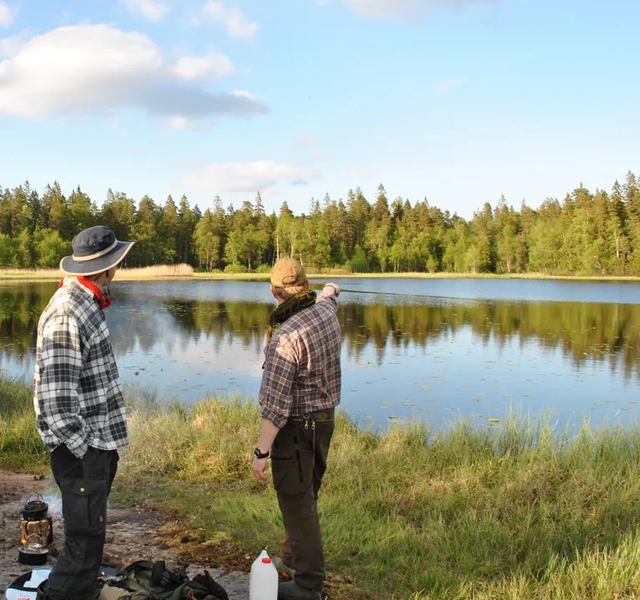 En grupp människor som står bredvid en sjö.