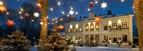 Ein großes weißes Gebäude, an dessen Seiten Weihnachtsbeleuchtung hängt.