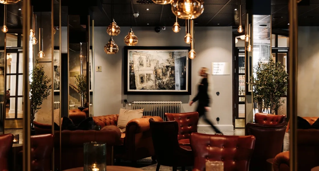 Kvinna passerar en tavla av Lars Lerin på Skara Stadshotell