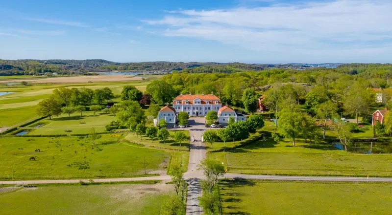 En flygbild av ett stort hus mitt på ett fält.