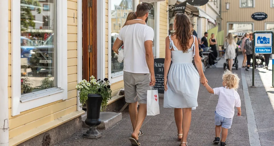A man and a woman walking down a street holding hands.