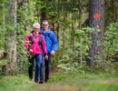 A man and a woman walking through a forest.