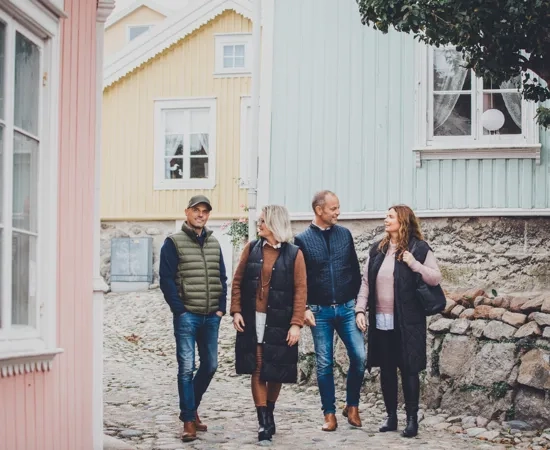 En grupp människor som går längs en kullerstensgata.