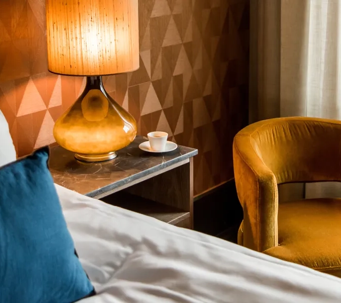 Ett hotellrum med ett sängbord med en stor lampa