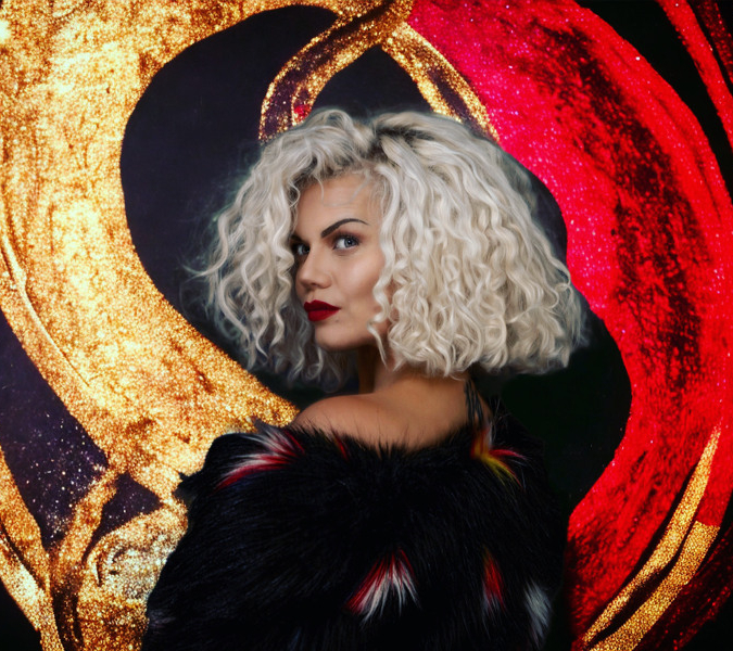 En kvinna med blont hår och svart päls.