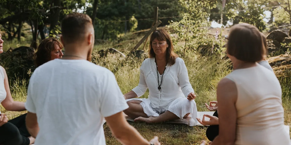 En gruppe mennesker som sitter i en sirkel og gjør yoga.