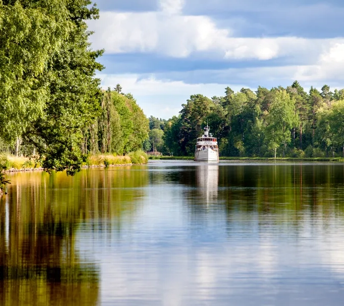 A boat on a lake surrounded by trees.