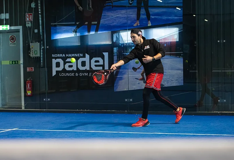 En man håller i en tennisracket på en tennisbana.