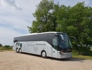 En turistbuss parkerad på en grusväg.