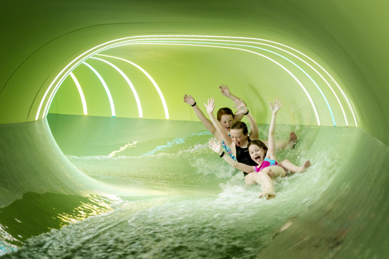 A family rides a water slide.