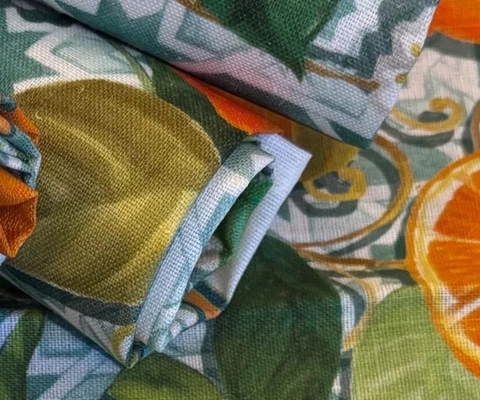 En närbild av en bordsduk med apelsiner på.