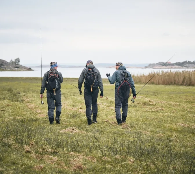 En grupp män som går över ett grönskande fält.
