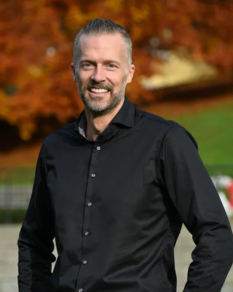 Man med kort hår i svart skjorta