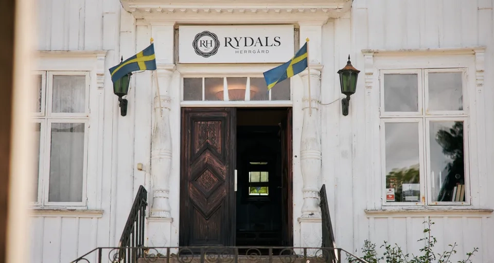 En vit byggnad med en flagga på framsidan.