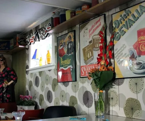 En kvinna står i ett kök bredvid ett bord.