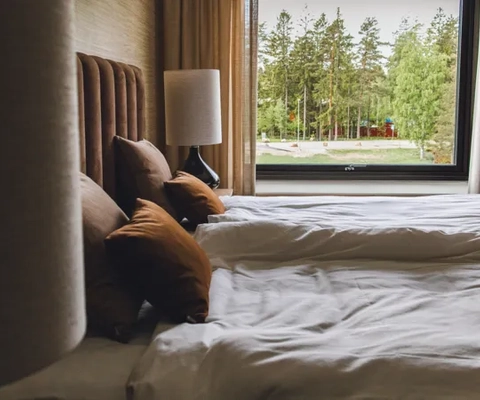 A hotel room with two beds and a large window.
