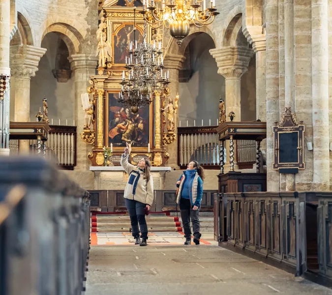 Två kvinnor inne i Varnhems Klosterkyrka