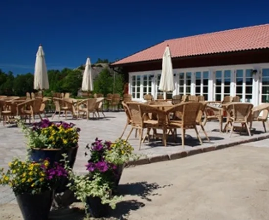 En uteplats med bord och stolar samt parasoller.