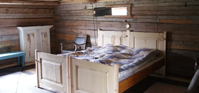 Ett sovrum med träväggar och en säng.