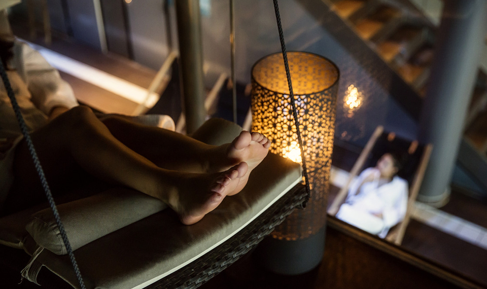 En tjej sitter i badstol med pool i bakgrunden