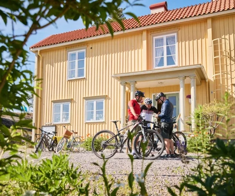 Grupp cyklister utanför ett vandrarhem.