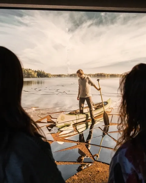 A group of people standing in front of a flat screen tv.