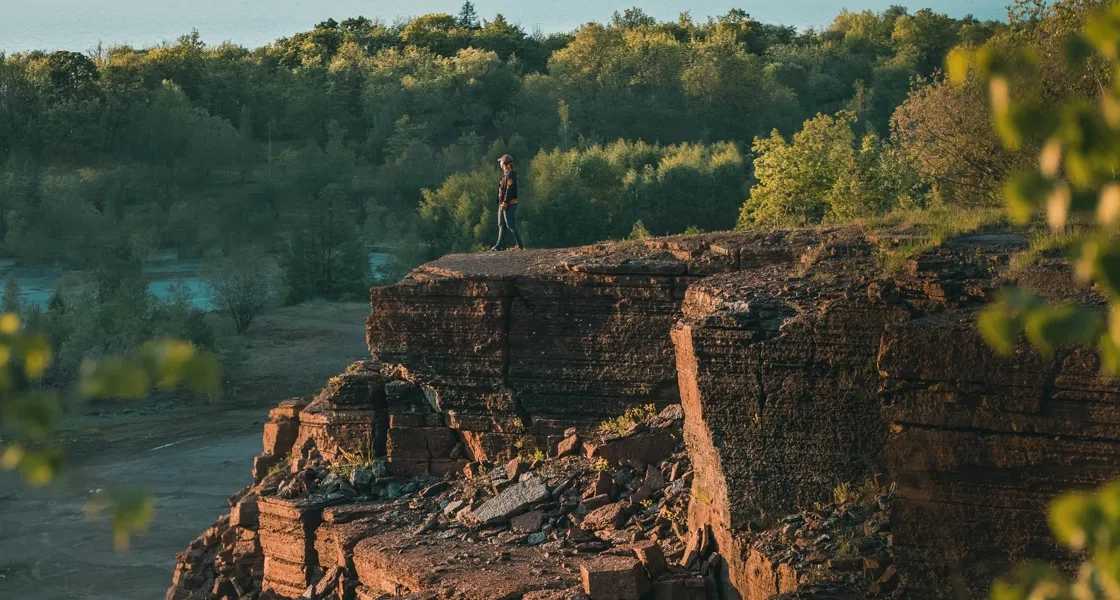 En person som står på toppen av en klippa.