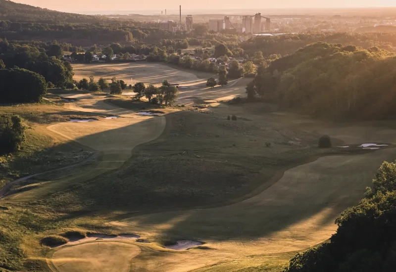 En utsikt över en golfbana med en flod som rinner genom den.