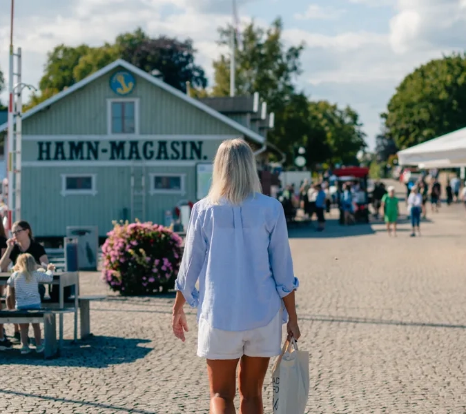 En kvinna som går längs en kullerstensväg.