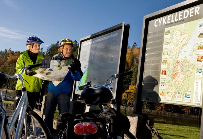Några personer som står bredvid en cykel.