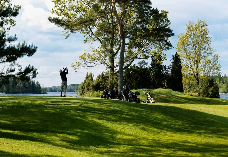 En golfbana med en sjö i bakgrunden.