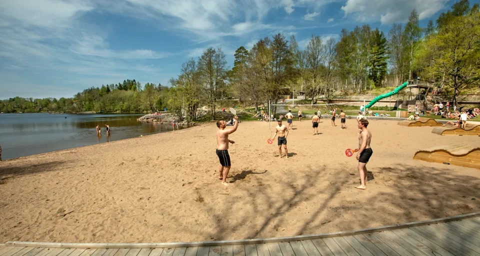 En grupp människor som står på en sandstrand.