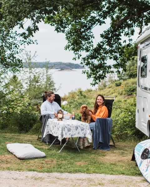 Människor sitter utanför en husbil.