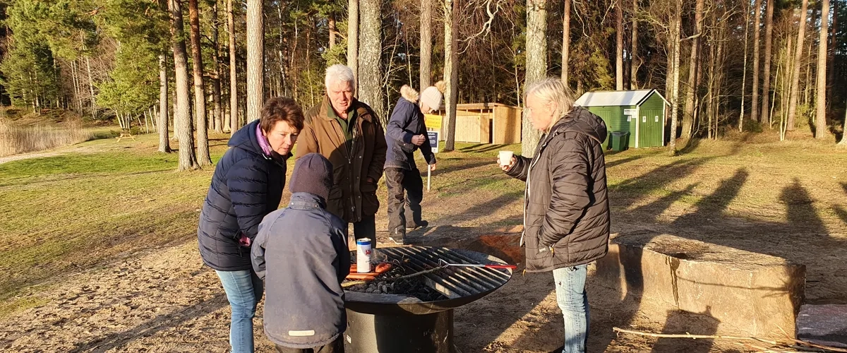 En grupp människor som står runt en eldstad.