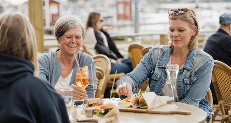 Några kvinnor sitter vid ett bord och äter mat.