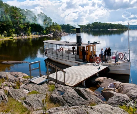 En båt förtöjd vid en brygga på en sjö.