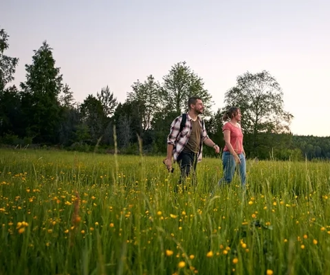 två personer som vandrar på en äng.