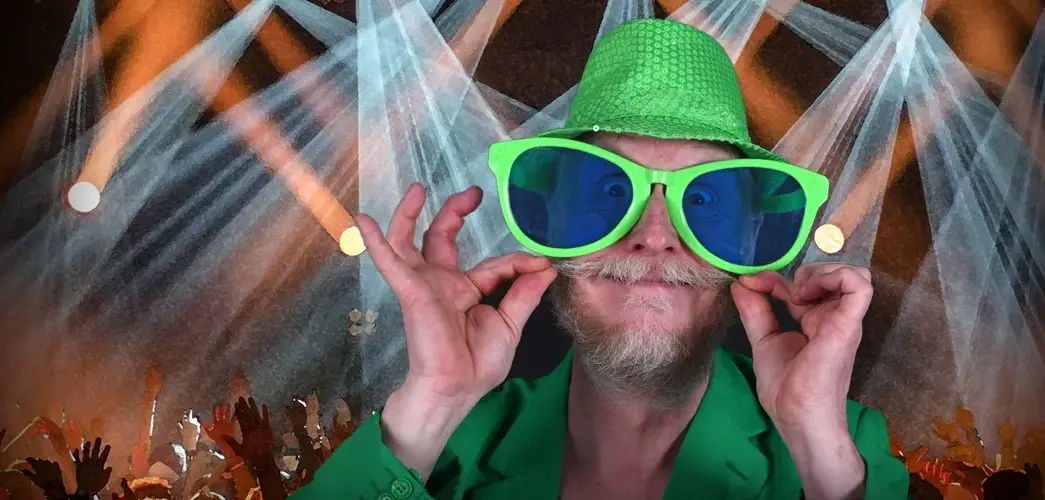 En man med gröna solglasögon och en grön hatt.