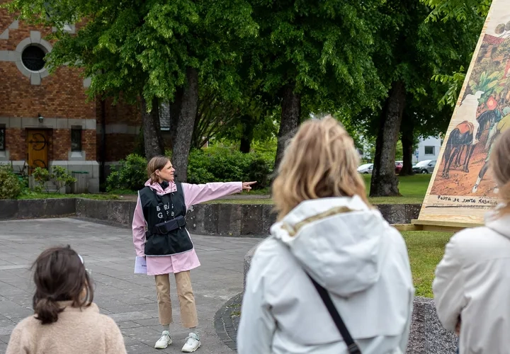 En grupp människor som står framför en målning.