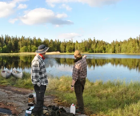 En grupp människor som står bredvid en sjö.