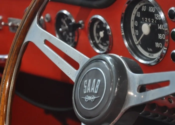 Närbild på en bilratt med Saabs logotyp