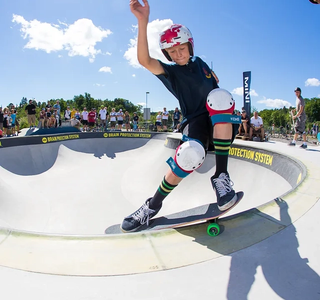 En ung man åker skateboard uppför sidan av en ramp.
