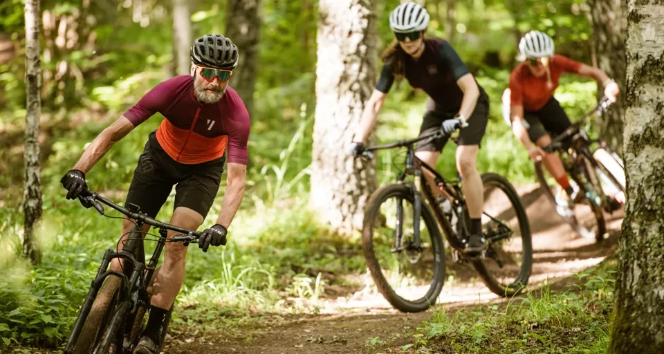 Tre personer som kör mountainbike
