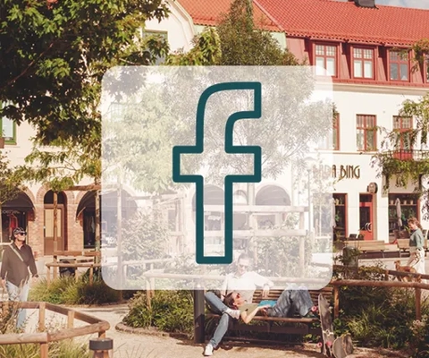 Facebookikon på ett bakgrundsfoto av torget