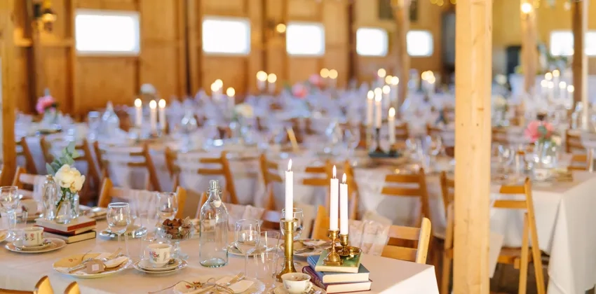 Ett rum fyllt med massor av bord täckta med vita dukar.